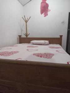 a bed with a white bedspread with pink flowers on it at Galoya Mahagedara in Inginiyagala