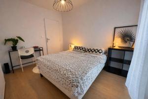 a bedroom with a bed and a table and a lamp at L'Instant Cocoon central-parking-4prs in Bourg-en-Bresse