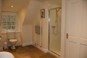 a bathroom with a shower and a toilet at Forget Me Not Holiday Cottage in Dalmellington +16 photos