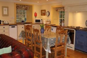 a kitchen with a table with chairs and a couch at Forget Me Not Holiday Cottage in Dalmellington