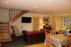 a living room with a couch and a table at Forget Me Not Holiday Cottage in Dalmellington