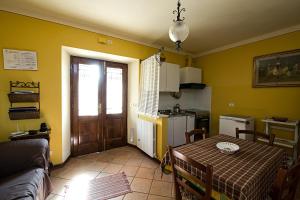 ein Wohnzimmer mit einem Tisch und einer Küche in der Unterkunft Cottage House Il Palazzetto in Castelnuovo di Garfagnana