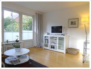 a living room with a tv and a table at Haus-Kim in Tinnum