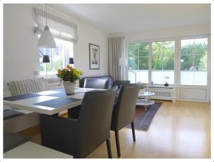a dining room and living room with a table and chairs at Haus-Kim in Tinnum