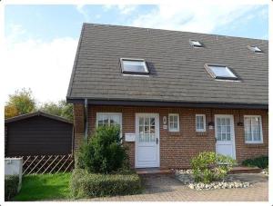 a brown brick house with white doors and windows at Haus-Kim in Tinnum