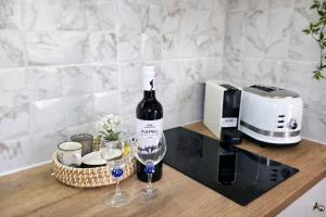 a bottle of wine and two glasses on a counter at Michele Marie apts in Agia Pelagia