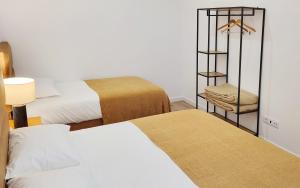 a hotel room with two beds and a chair at Casa João de Quintal in Elvas