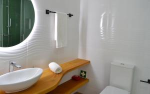 a white bathroom with a sink and a mirror at Casa João de Quintal in Elvas
