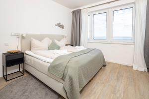 a bedroom with a large bed and a window at Ostsee Suite 5 - Strandperle in Niendorf