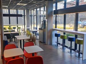 a restaurant with tables and chairs and windows at Ibis Budget Amiens Centre Gare in Amiens