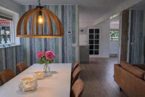 a dining room with a table with flowers on it at Ballumerhoeve t Pandje in Ballum