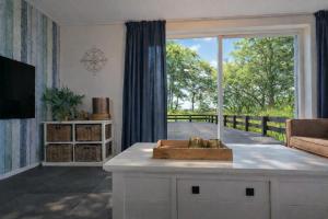 a living room with a large window and a table at Ballumerhoeve t Pandje in Ballum