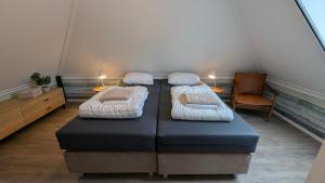 a room with two beds and a table with a chair at Ballumerhoeve t Pandje in Ballum