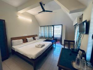 a bedroom with a large bed and a table at HOTEL IHAM PARADISE - Near Mangalore Central Railway Station - Pets Not Allowed in Mangalore