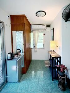 a kitchen with a refrigerator and a table in it at Firefly Bungalows Samui in Ban Bang Po