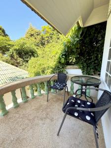a patio with two chairs and a table on a balcony at Firefly Bungalows Samui in Ban Bang Po