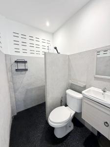 a bathroom with a white toilet and a sink at Firefly Bungalows Samui in Ban Bang Po +12 photos