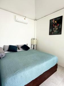 a bedroom with a large bed with a blue blanket at Firefly Bungalows Samui in Ban Bang Po