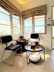 two chairs and a table in a room with windows at Firefly Bungalows Samui in Ban Bang Po
