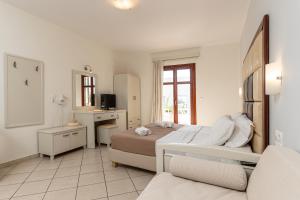 a white bedroom with a bed and a mirror at Plaka Hotel II in Plaka