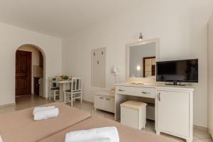 a living room with two beds and a television at Plaka Hotel II in Plaka