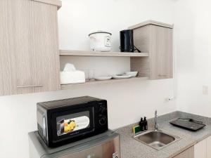 a microwave sitting on top of a kitchen counter at Affordable Stylish & Cozy Walk Up Condo in Minglanilla