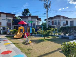 a playground with a slide in a yard at Affordable Stylish & Cozy Walk Up Condo in Minglanilla