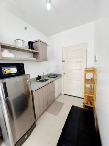 a small kitchen with a refrigerator and a sink at Affordable Stylish & Cozy Walk Up Condo in Minglanilla +5 photos