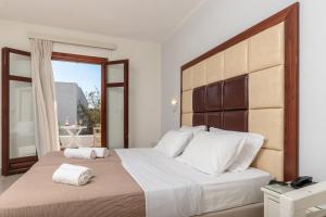 a bedroom with a large bed with two towels on it at Plaka Hotel II in Plaka +70 photos