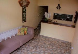 a living room with a couch and a television at Hostal B&C in Angra dos Reis