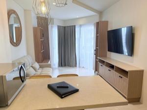 a living room with a couch and a television at Tambuli Ocean View Luxe Studios, Mactan Seaside Residences in Lapu Lapu City