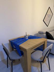 a wooden table with two chairs and a blue table cloth at Molly Nest in Gjakove