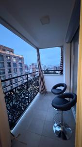 a balcony with two chairs and a view of a city at Molly Nest in Gjakove