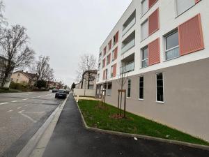 a building on a street with a car parked next to it at L'Instant Cocoon central-parking-4prs in Bourg-en-Bresse