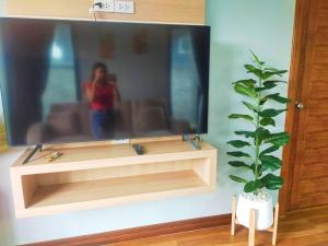 a person taking a picture of a tv in a living room at Aonang Homie Pool villa in Ao Nang 