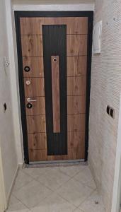 a wooden door in a hallway with a tile floor at Lune in Sidi Yahia az Zaʼer