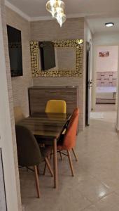 a dining room with a wooden table and yellow chairs at Lune in Sidi Yahia az Zaʼer