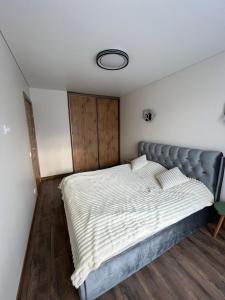 a bedroom with a large bed with white sheets at Modern apartment with Private parking - 10 min to airport, 15 min Center in Vilnius