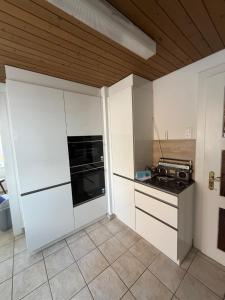 a kitchen with white cabinets and a stove at Urlaub am Bodensee in Staad - einmalige Seesicht in Staad