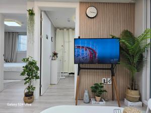 ein Flachbildfernseher in einem Zimmer mit Pflanzen in der Unterkunft Gate 303 in Seoul