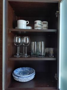 a cupboard with plates and glasses and a plate at Városközpont Tata in Tata