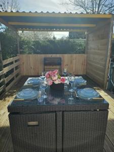 a table with plates and flowers on a patio at mobil-home in Souméras