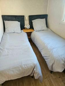 two beds sitting next to each other in a bedroom at mobil-home in Souméras +9 photos