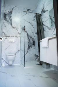 a bathroom with a glass shower and a toilet at Hotel Le Centenaire Brussels Expo in Brussels +54 photos