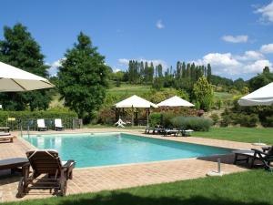 モントーネにあるModern Holiday Home in Montone with Poolの大型スイミングプール(椅子、パラソル付)