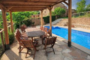 a patio with a table and chairs next to a swimming pool at Casa con piscina y vistas a montaña - Cal Solsona in La Baronia de Rialb