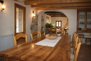 a dining room with a wooden table and chairs at Casa con piscina y vistas a montaña - Cal Solsona in La Baronia de Rialb