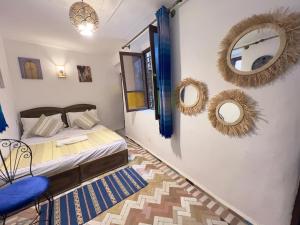 a bedroom with a bed and mirrors on the wall at Dar Jnan EL Sbil in Fez
