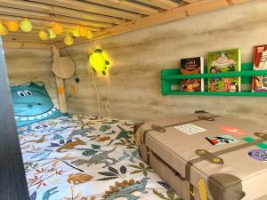 a childs bedroom with a bed and a green shelf at Le Ptit studio du vieux moulin in Rochefort +35 photos