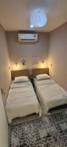 two beds in a small room with a fan at Le Melur in George Town